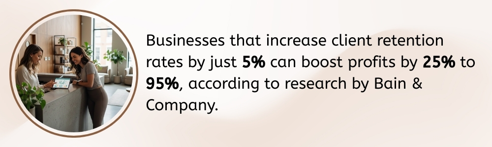 Receptionist showing client retention stats on device in real wellness studio